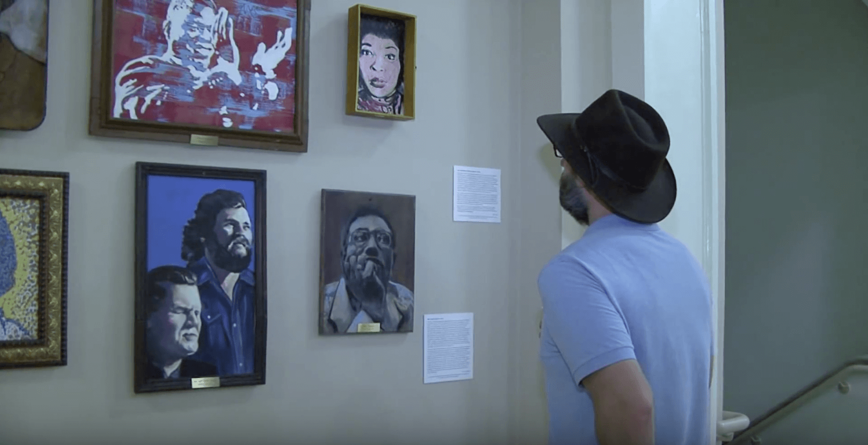 Person observes paintings at their new home in Hill Hall.