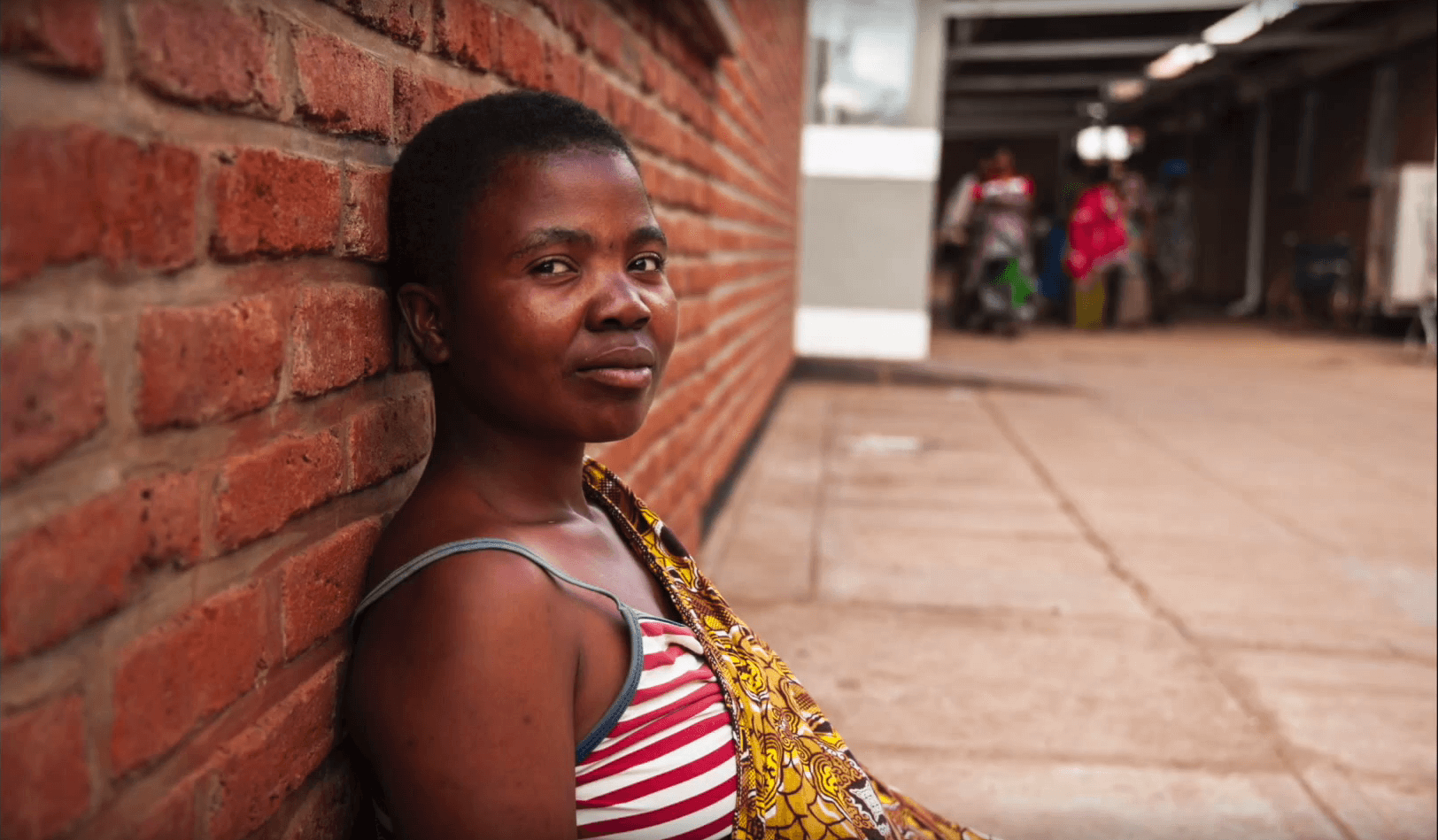 Woman sits on the street in Malawi.