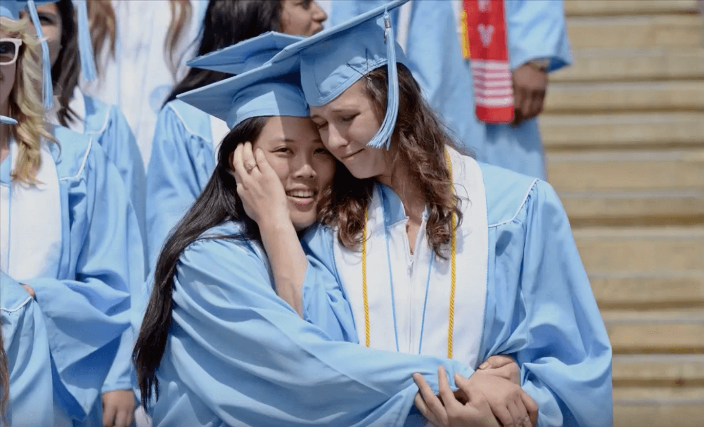 Two graduates embrace.