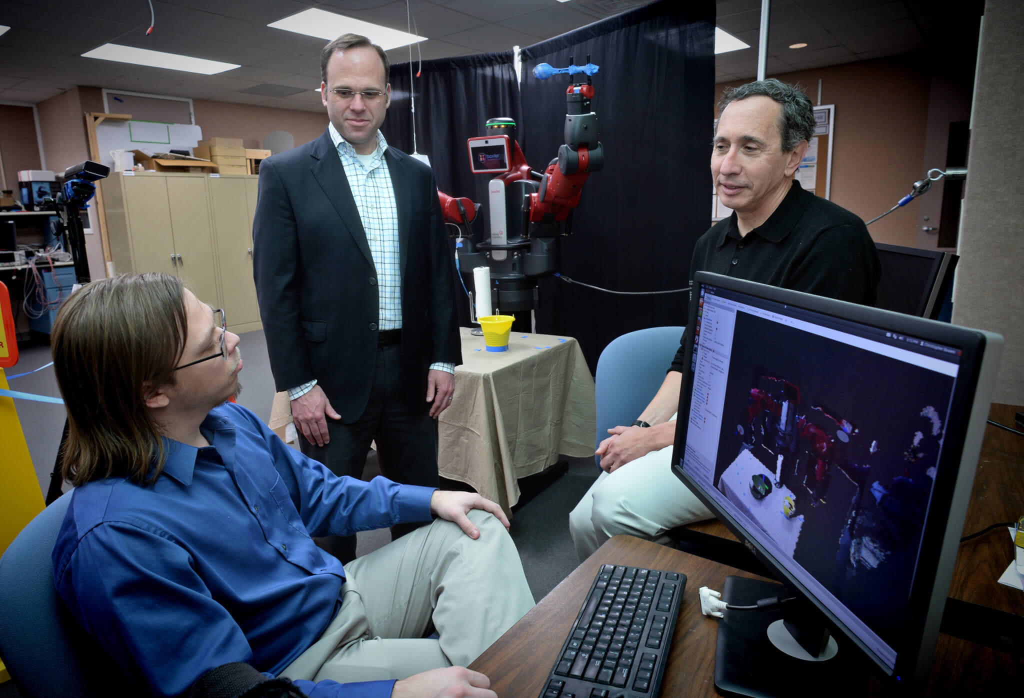 Kevin Jeffay, left, and Michael Fern talk with graduate student Chris Bowen, seated, in the robotics lab in the Department of Computer Science at the University of North Carolina at Chapel Hill
