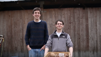Carolina students Will Chapman and Patrick Mateer hold a box of produce