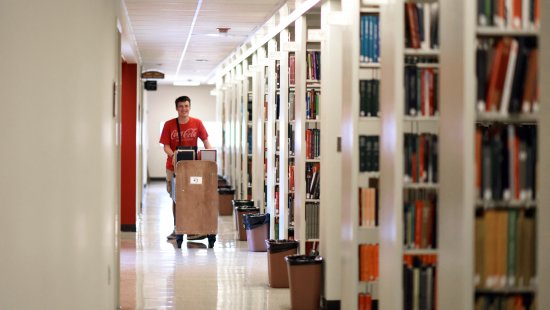Brian O'Donnell walks down the library stacks.