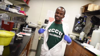 Prince Neequaye opening lab coat to show NC Central T-shirt.