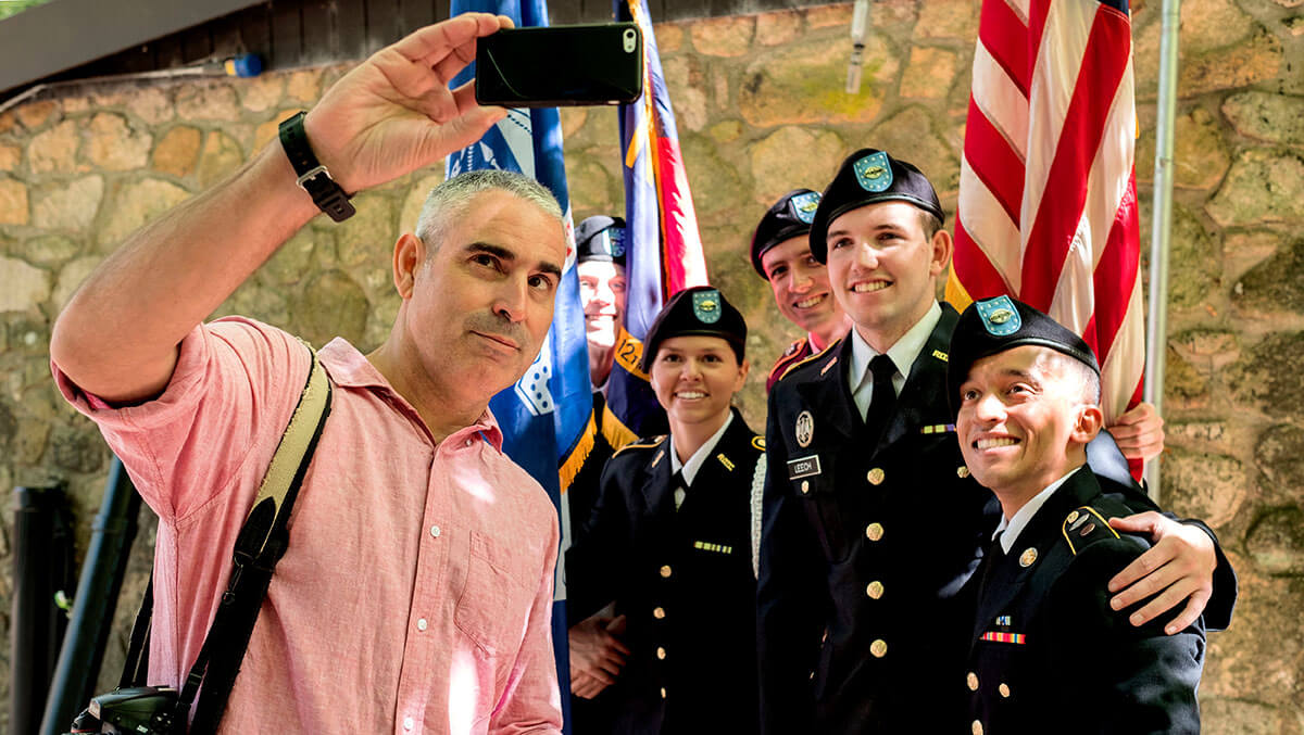 Photographer Louie Palu takes a photo with members of the ROTC.