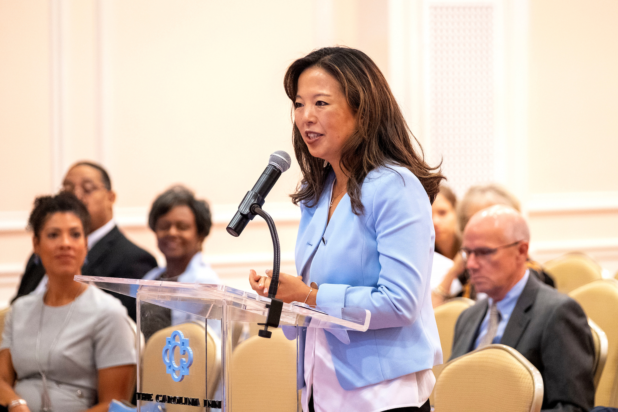 Jessica Lee speaks at a podium at a meeting