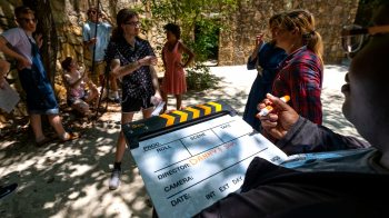 A student writes on a director's clapperboard.
