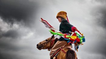 Little boy on a horse under stormy skies