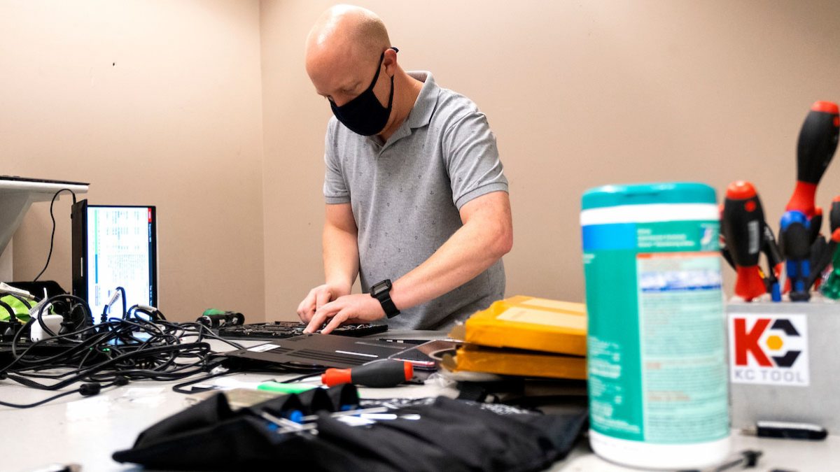 A man repairs a laptop.