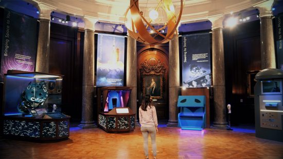 A person stands in the lobby of Morehead Planetarium and Science Center.