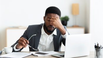 A man looks stressed at his computer.