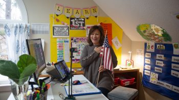 Suzanne Zaccardo holds an American flag while saying the pledge of allegiance.
