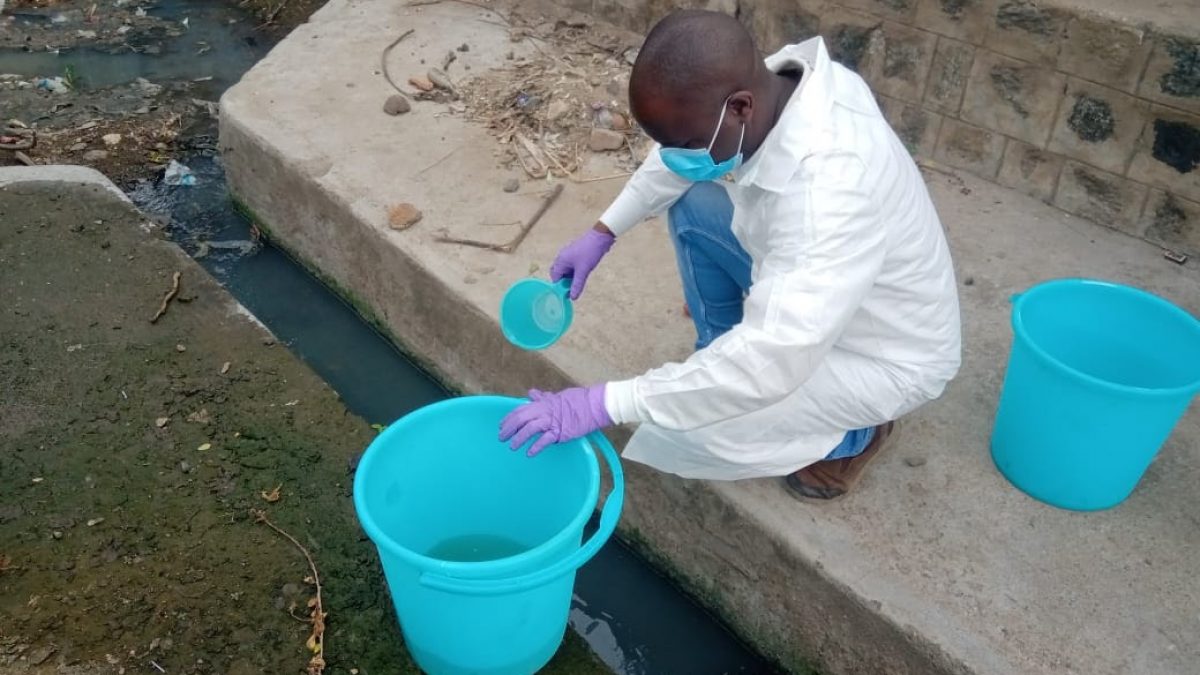 A man pours a water sample into a bucket.