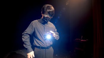 A man performing a magic trick with a light.