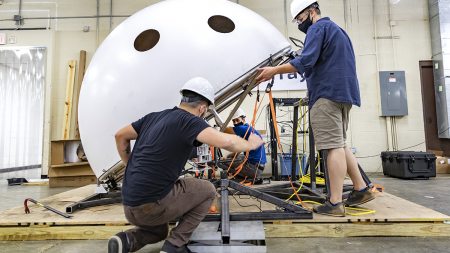 Two men work on the telescope dome.