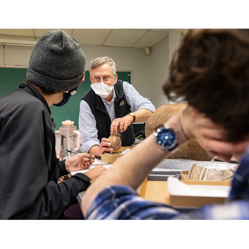 A professor talks with students.