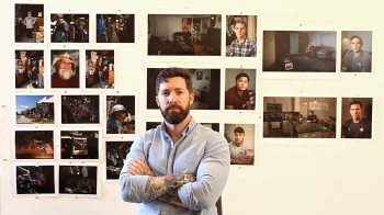 Matthew Troyer in front of his photography