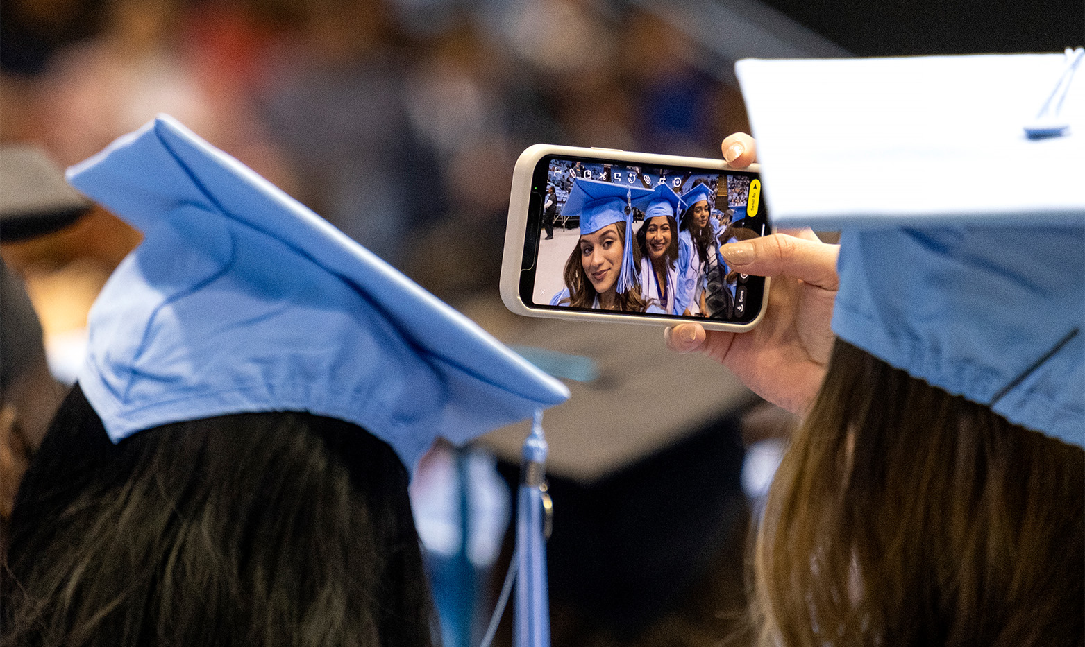Students take a selfie in their cap and gowns.