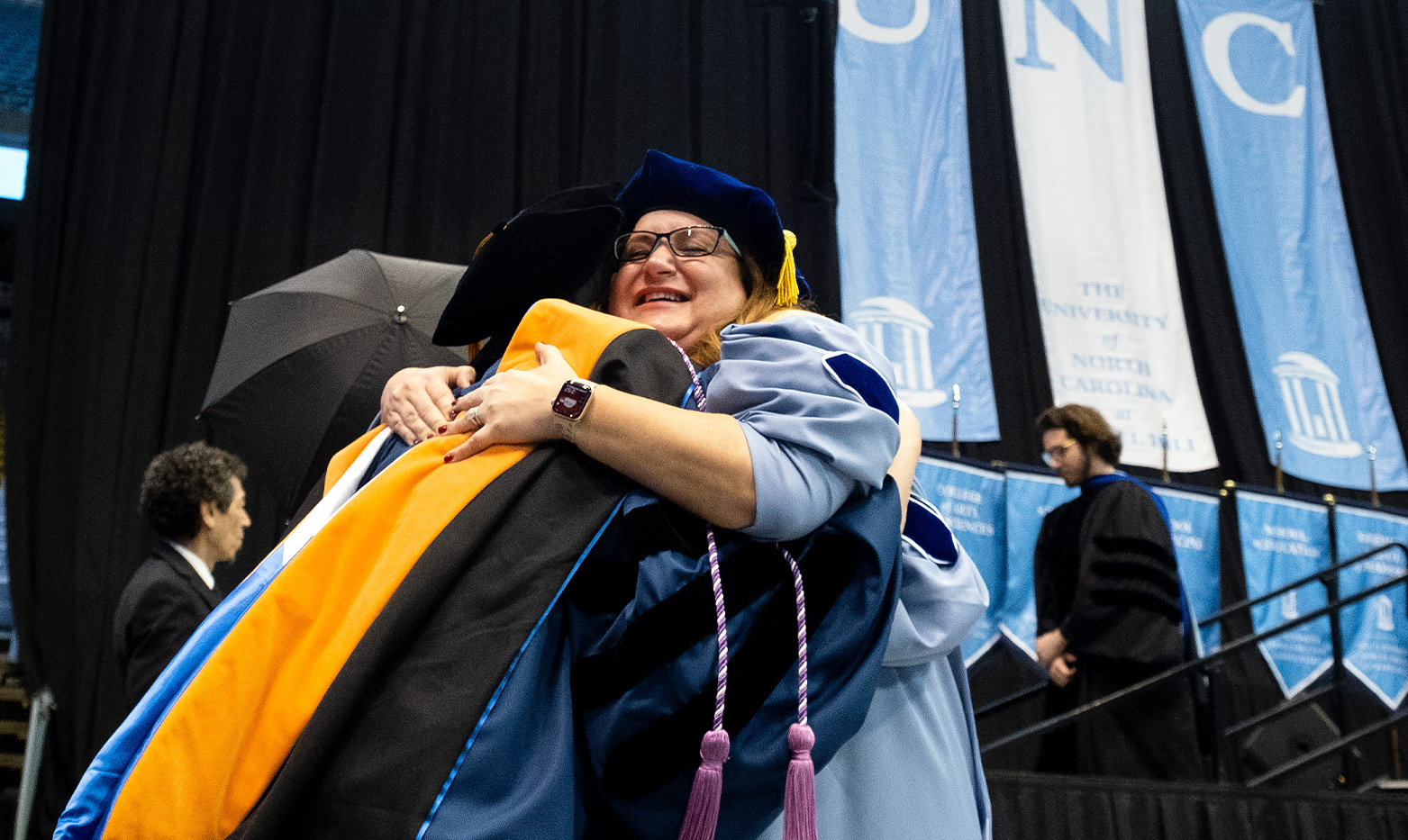Two graduates hugging.