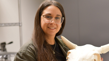 A person holding an animal skull.
