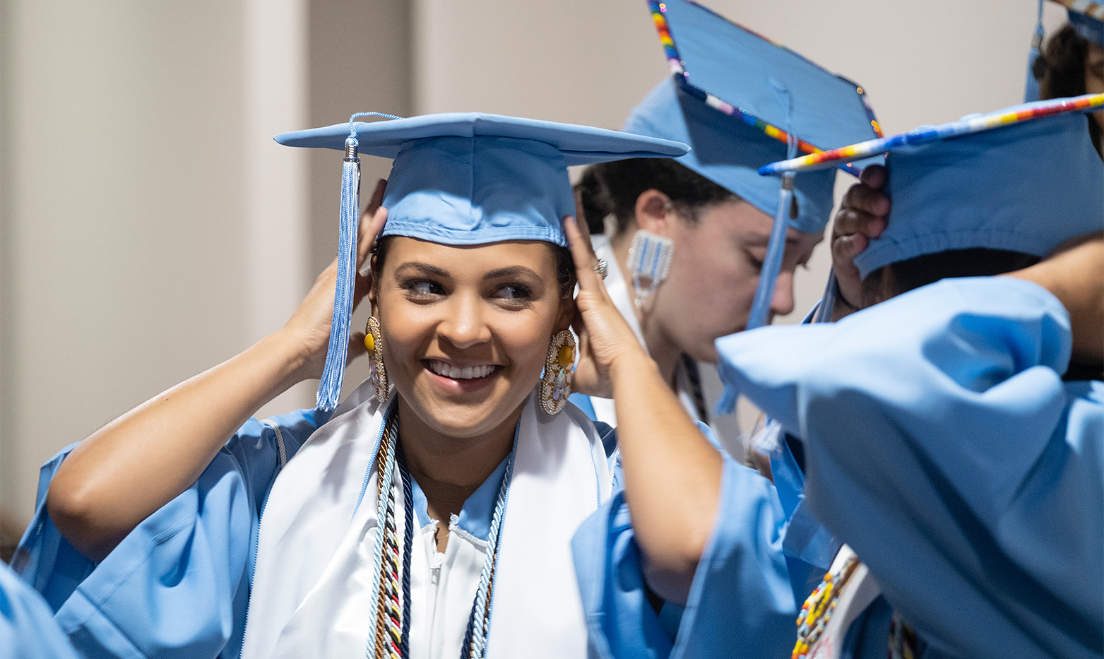 A graduate adjusting their graduation cap.