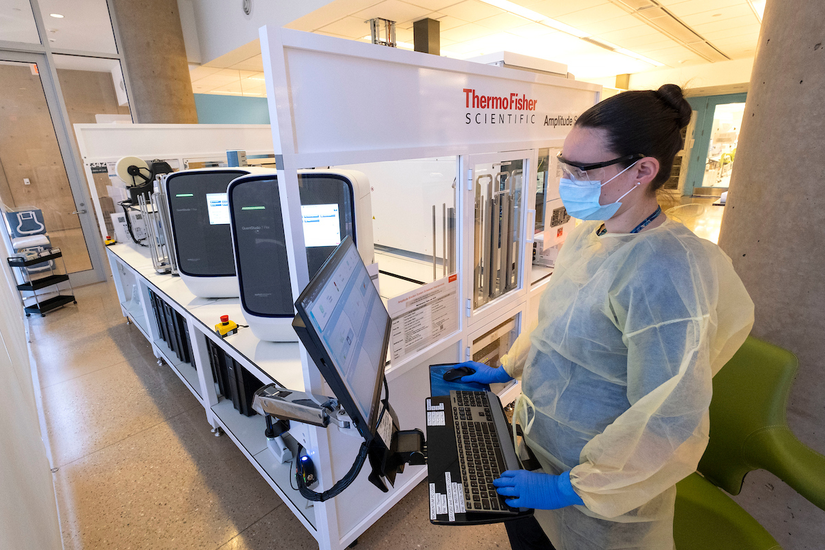 4.Olivia Council demonstrates the PCR testing machine at the UNC-CH COVID Surveillance Laboratory. Samples are brought to this lab where they are run through a Polymerase Chain Reaction (PCR) testing process to determine if the sample is positive or negative for COVID-19.