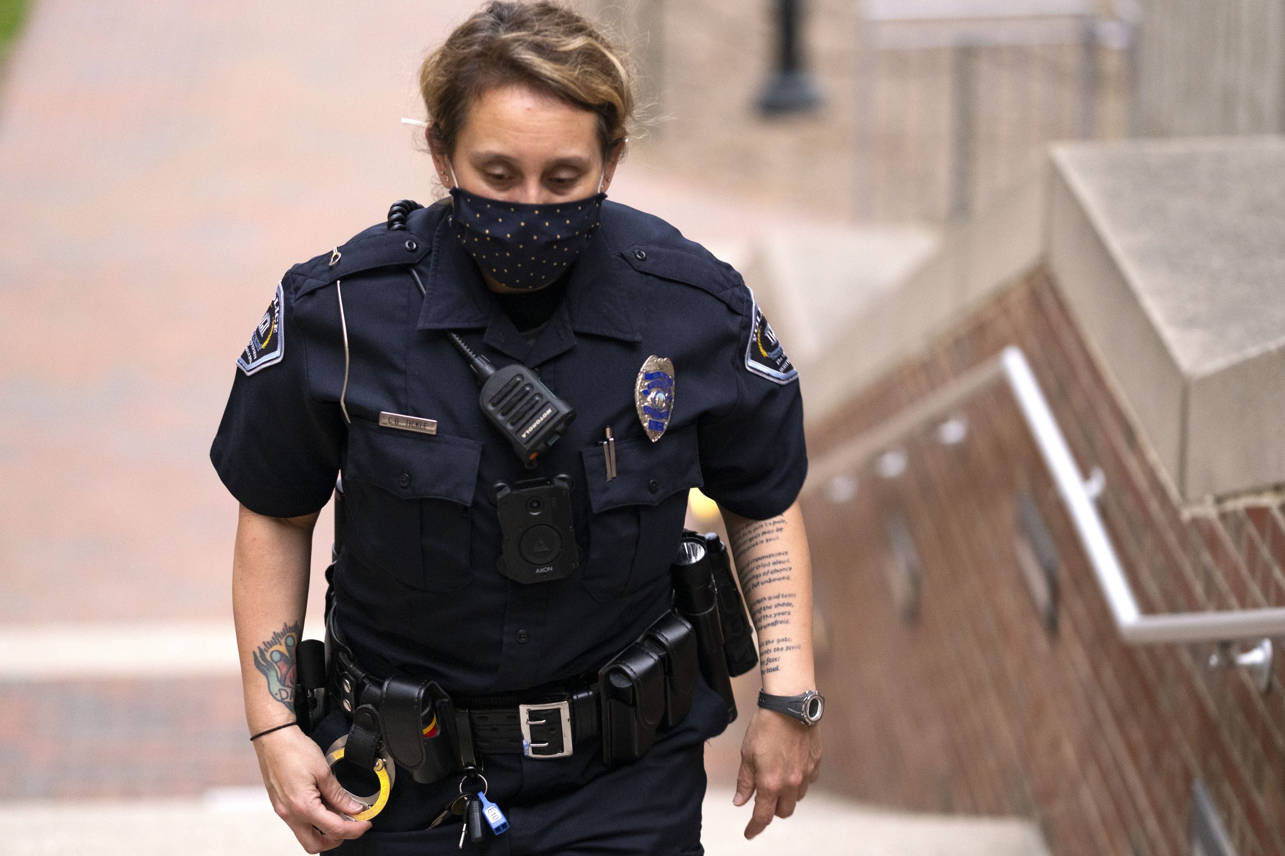 Female officer wearing a Covid mask walking up steps outdoors.