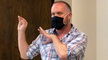 Teaching associate professor Michael Gutierrez teaches while masked.