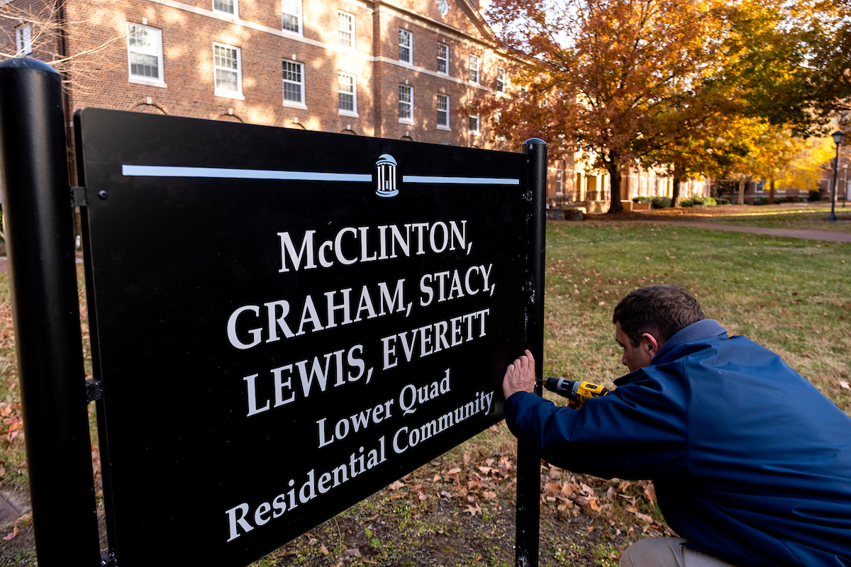 Josh Clark,with, UNC Facilities, installs a pedestrian sign for the newly named McClinton Building Residence Hall on the campus of the University of North Carolina