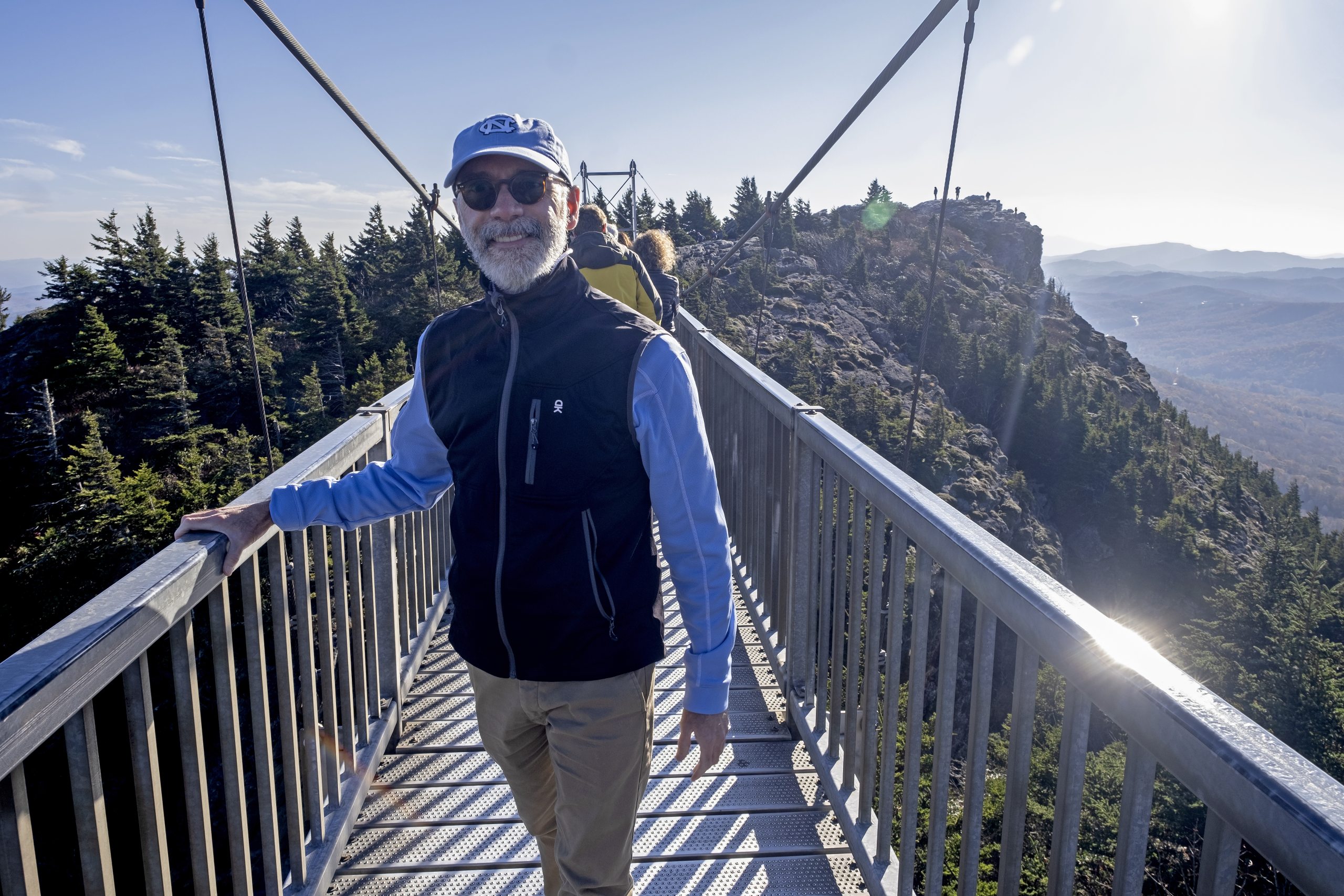 Man on a swinging bridge at the top of a mountain