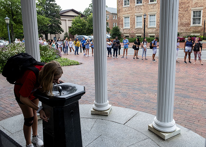 Students in 2018 line up for a sip from the Old Well.