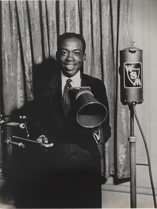 Publicity still from WSM radio showing Deford Bailey in front of microphone.