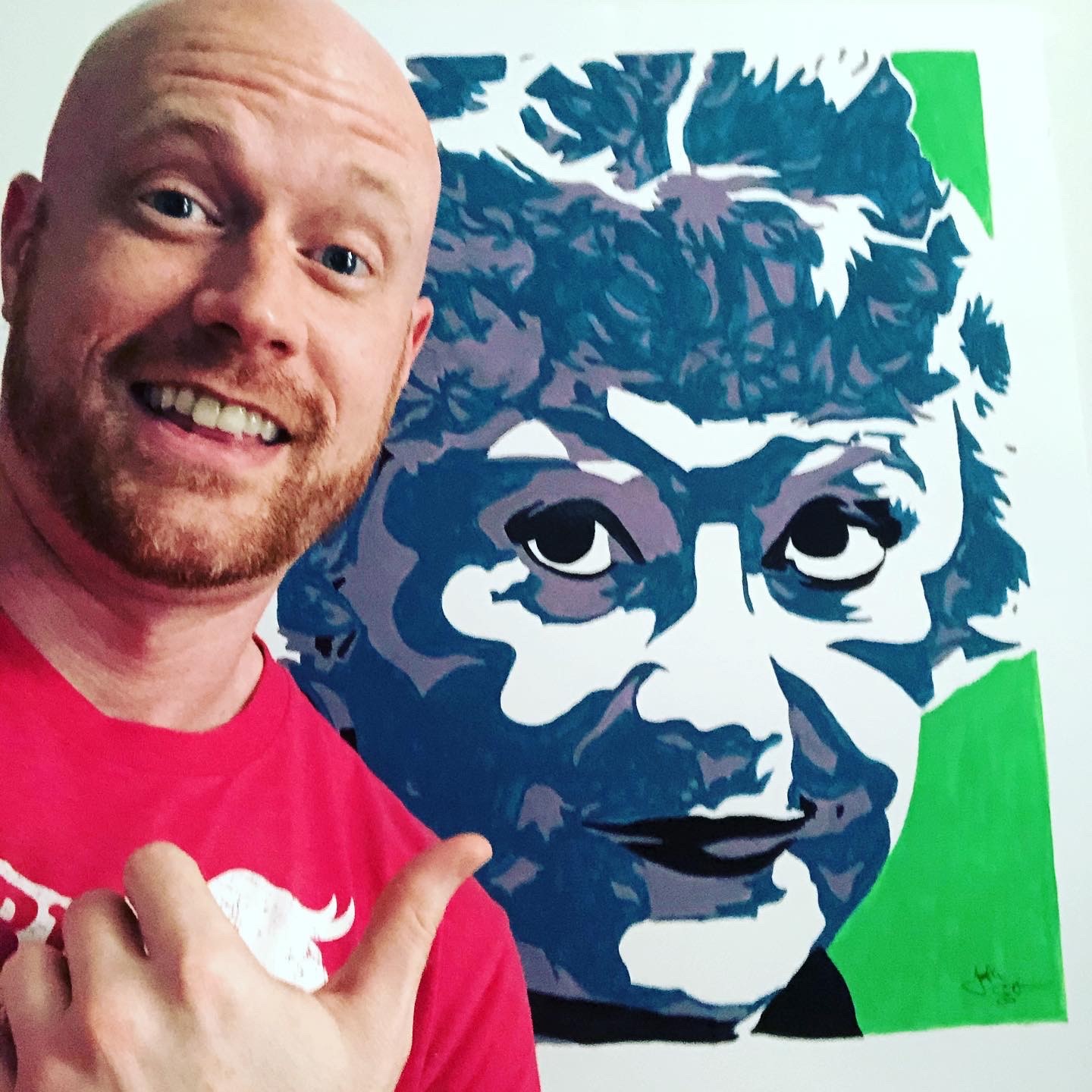 Painter Jonathan Earnest in front of a portrait of actor Bea Arthur.