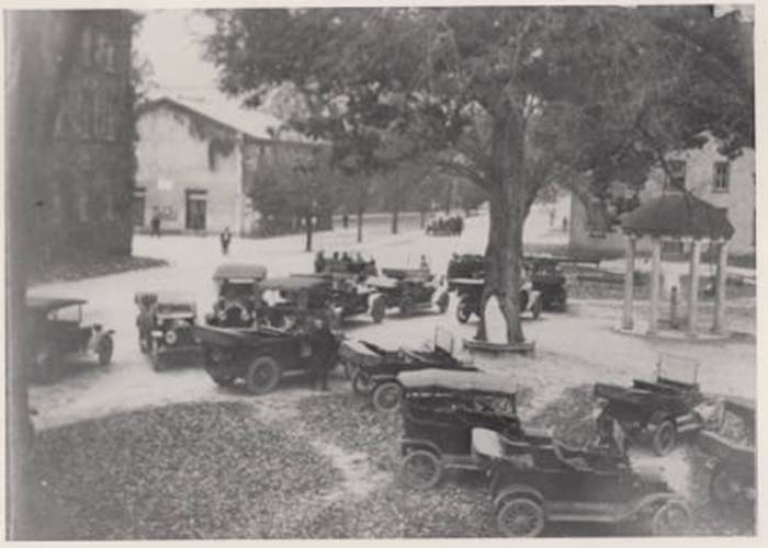 Old Well in 1920s or 1930s with jalopies parked all around it.