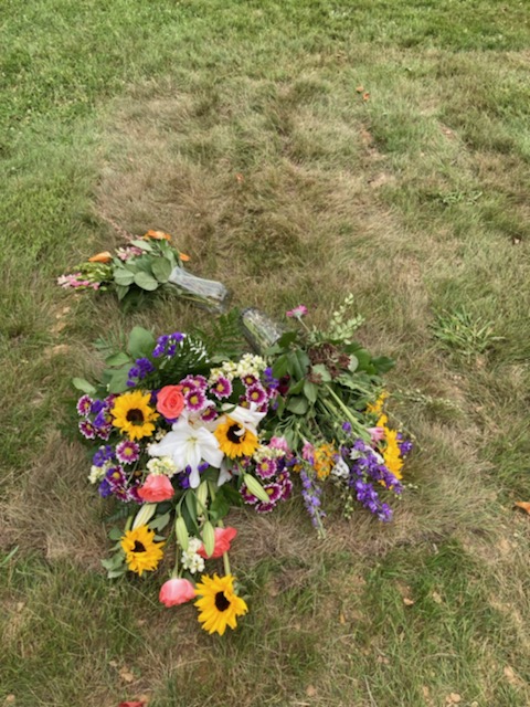 freshly dug grave with flowers.