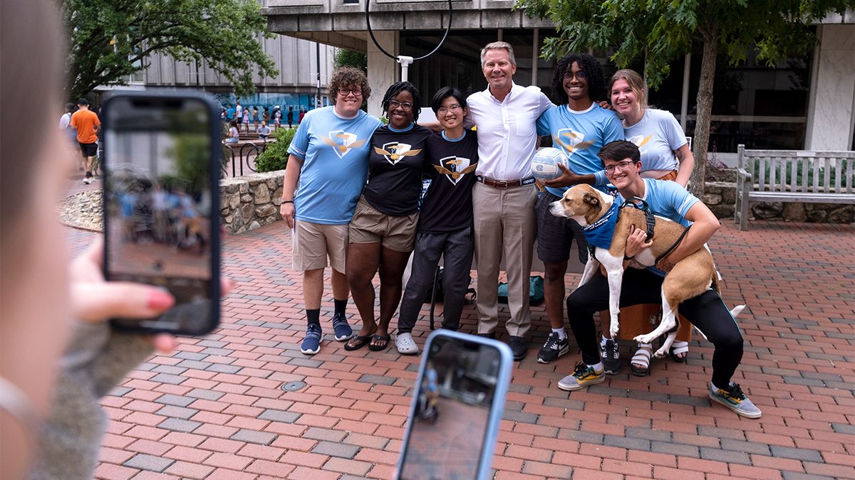 Chancellor Guskiewicz and a group of students near the Frank Porter Graham Student Union