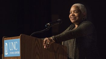 McNeil smiling at podium while she greets attendees at the 2017 African American History Month lecture. Photo by Jon Gardiner.