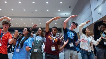 Incoming UNC-Chapel Hill students participating in an orientation activity and contorting their bodies to spell the letter 