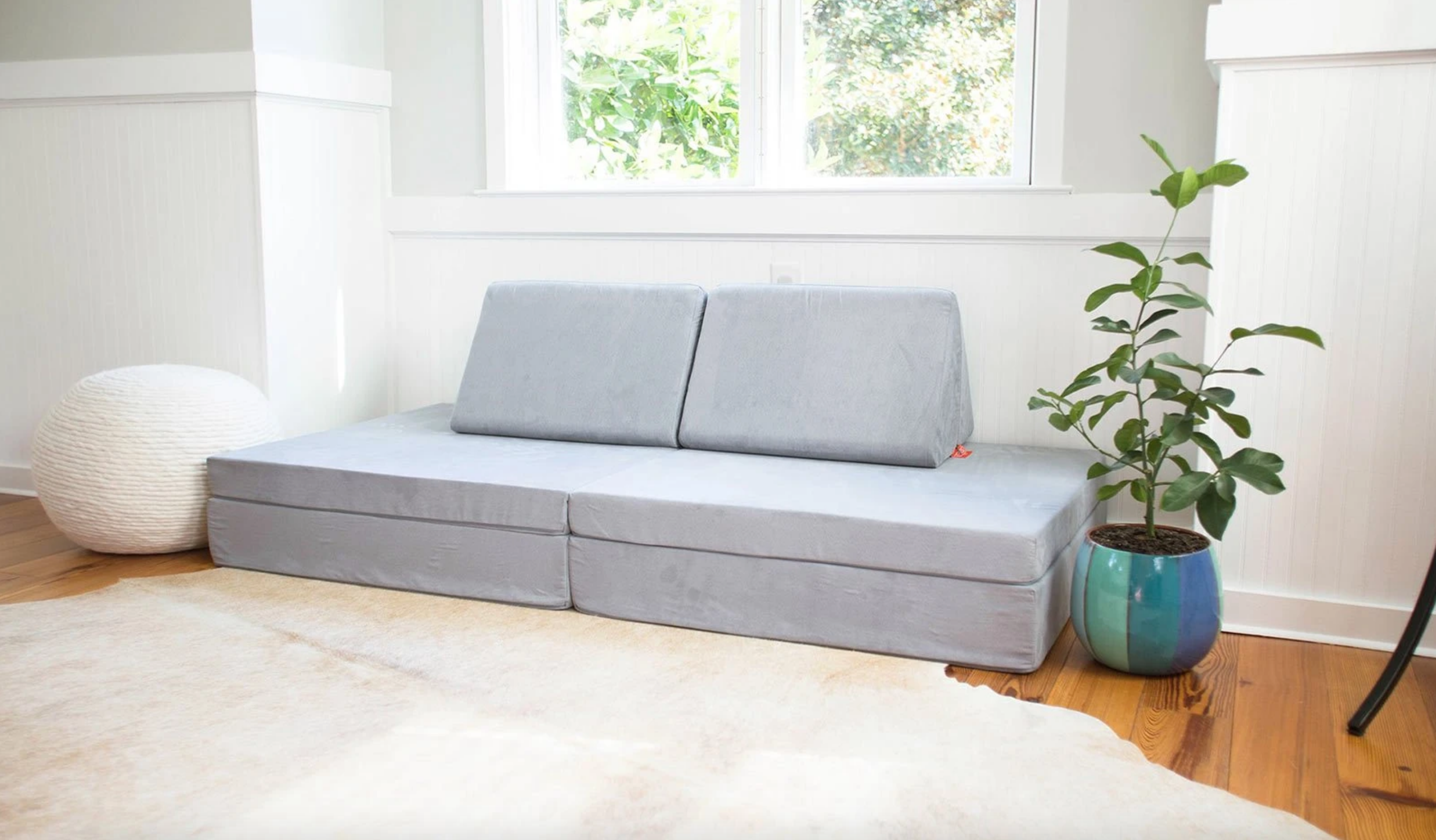 Light gray nugget sofa in room next to potted plant.