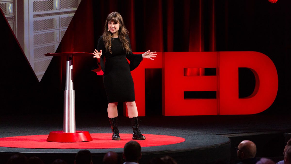 A person giving a Ted talk on stage