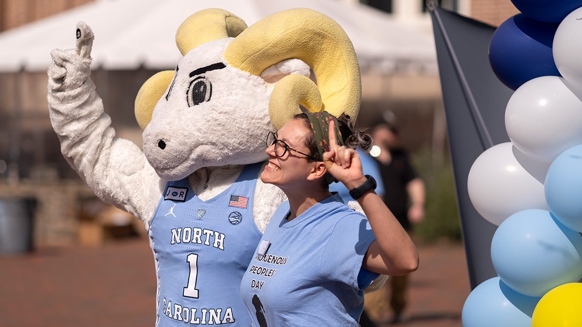 Person poses with Rameses near the Pit.