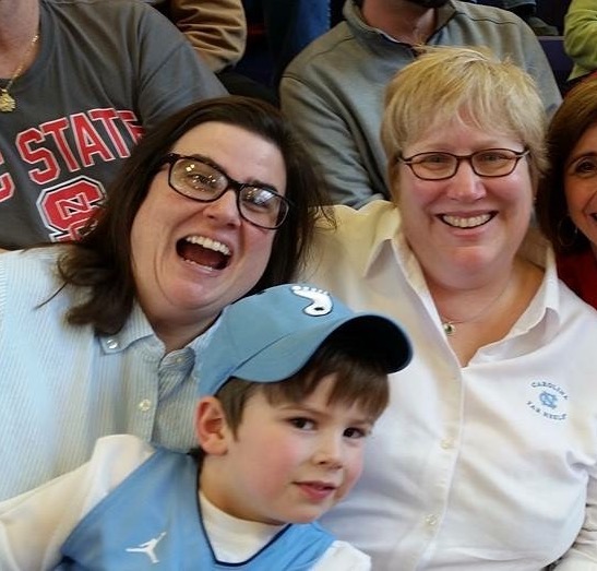 Janice Anderson, right, with her wife Paige and son Logan, at a Tar Heel women's basketball game.