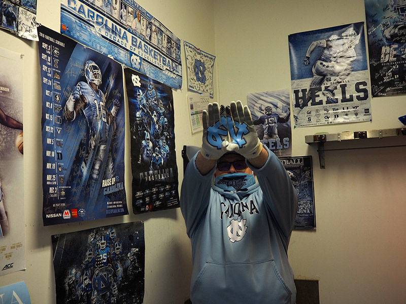 Jimmy Smith at his workplace, which has many posters for UNC football on the walls.