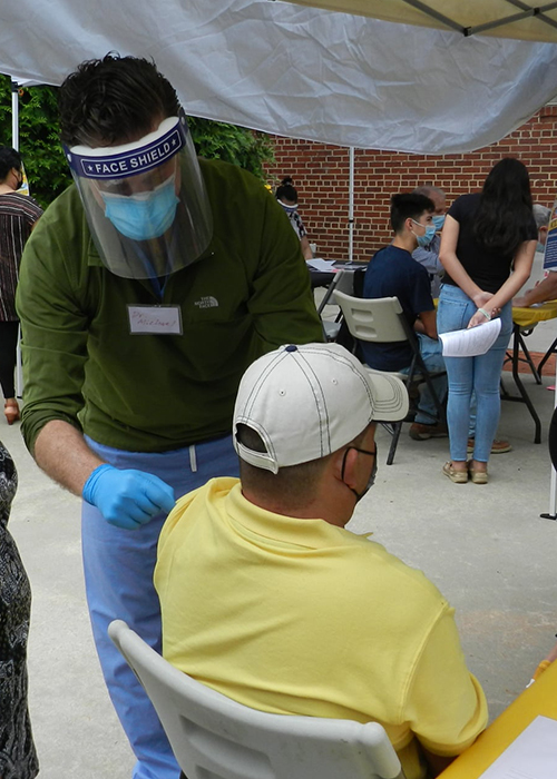 Doctor Herce prepares to give a COVID vaccination to a person at the Siler City health fair. 