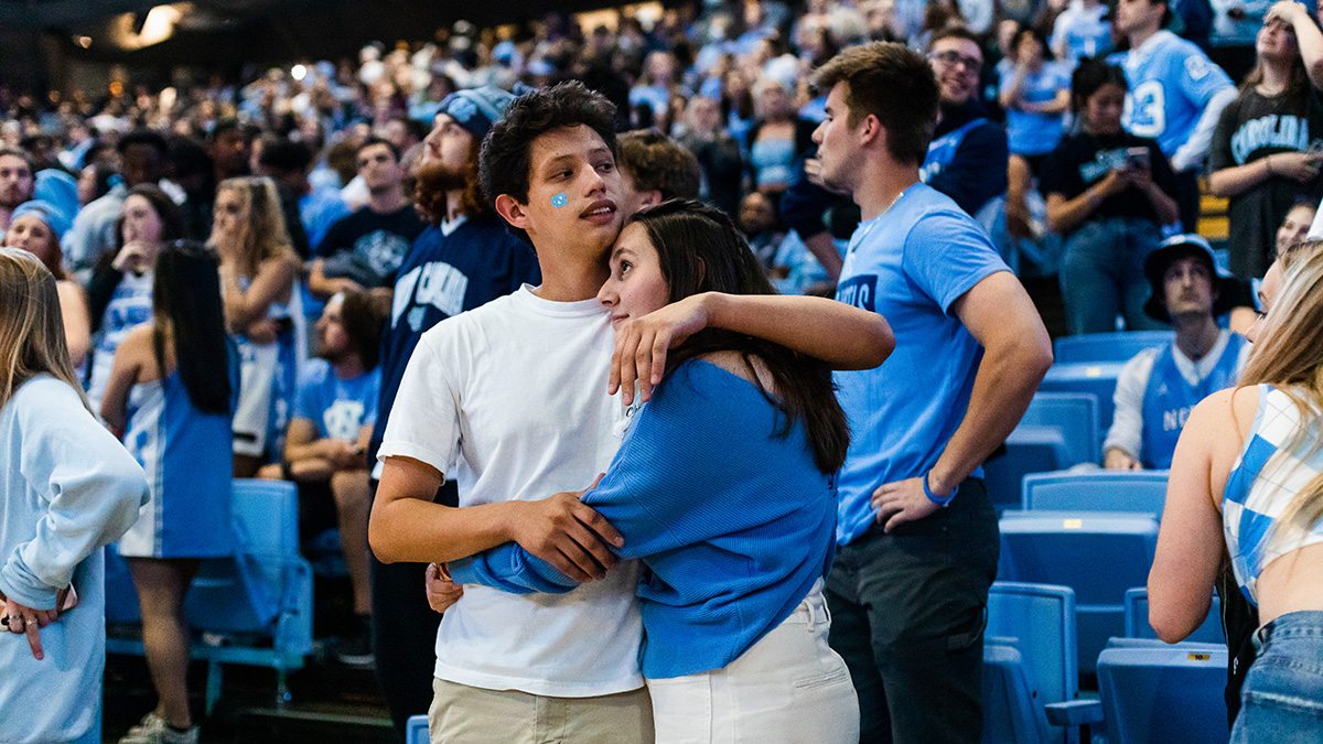 A couple embraces amid stands of Carolina fans