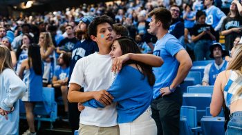 A couple embraces amid stands of Carolina fans