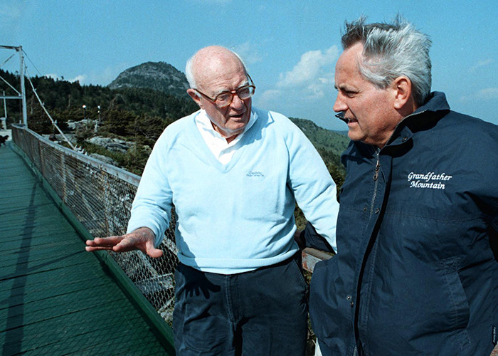 In 1998, Grandfather Mountain owner Hugh Morton, left, chats with Chancellor Michael Hooker on the mountain's famous Mile High Swinging Bridge. Tour participants talked with Morton about the effects of acid rain on upper-level forests. (Dan Sears/UNC-Chapel Hill)