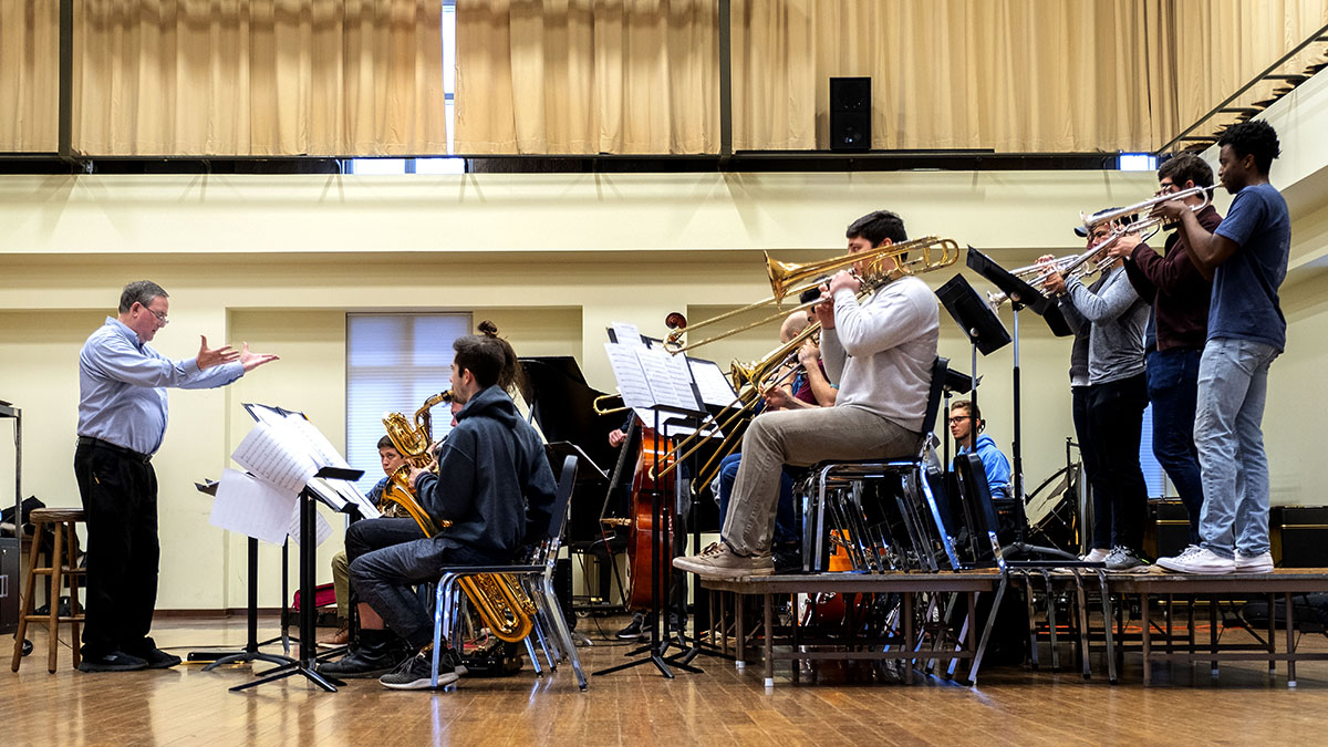 Jim Ketch raises his hands as he directs a rehearsal of the 15-student UNC Jazz Ensemble.