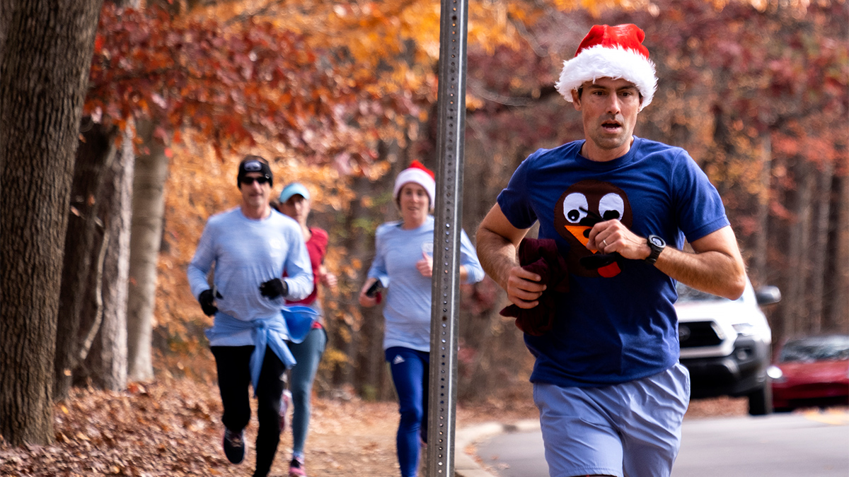 Group of runners, two with Santa hats.