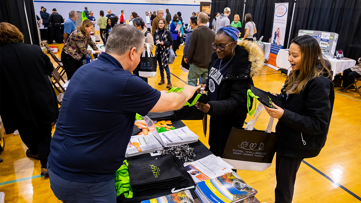 Happy employees collect swag at the Wellness Resource Fair.