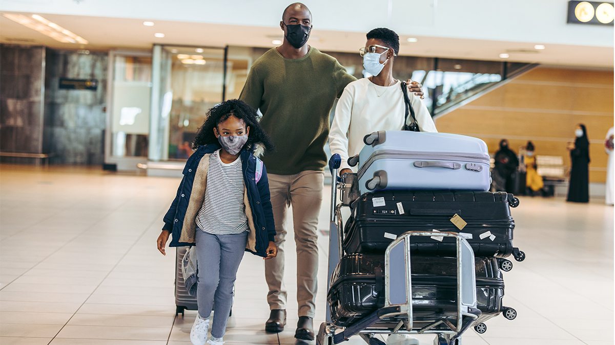 A family wearing masks in the airport